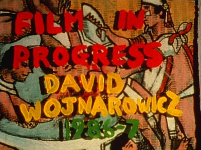 Still from A Fire In My Belly (1986-87). Handwritten text in red paint reads "FILM IN PROGRESS,"
